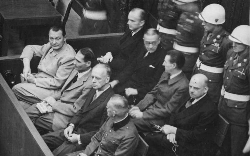 Procès de Nuremberg. Les accusés dans leur box, circa 1945-1946. Au premier rang, de gauche à droite&nbsp;:&nbsp;Hermann Göring,&nbsp;Rudolf Heß,&nbsp;Joachim von Ribbentrop,&nbsp;Wilhelm Keitel. Au deuxième rang, de gauche à droite :&nbsp;Karl Dönitz,&nbsp;Erich Raeder,&nbsp;Baldur von Schirach,&nbsp;Fritz Sauckel - Photo :&nbsp;U.S. Army 